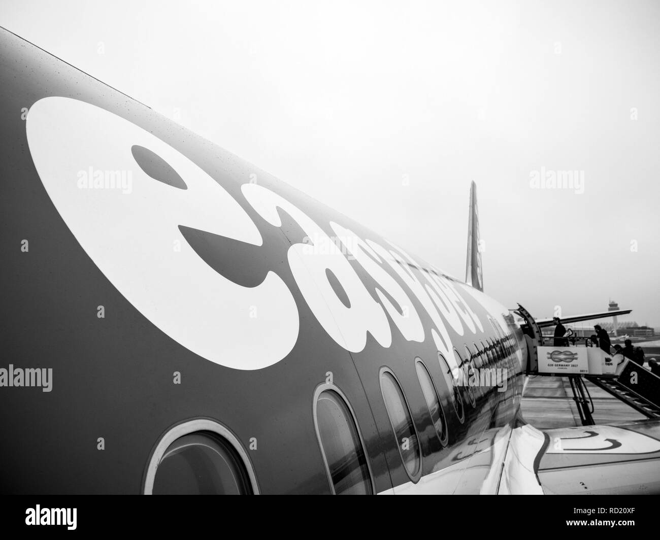 HAMBURG, DEUTSCHLAND - Mar 22, 2018: das Logo von EasyJet Flugzeug am frühen Morgen im Flughafen Hamburg durch die hintere Beifahrertür jetway Treppen - Schwarz und Weiß Stockfoto