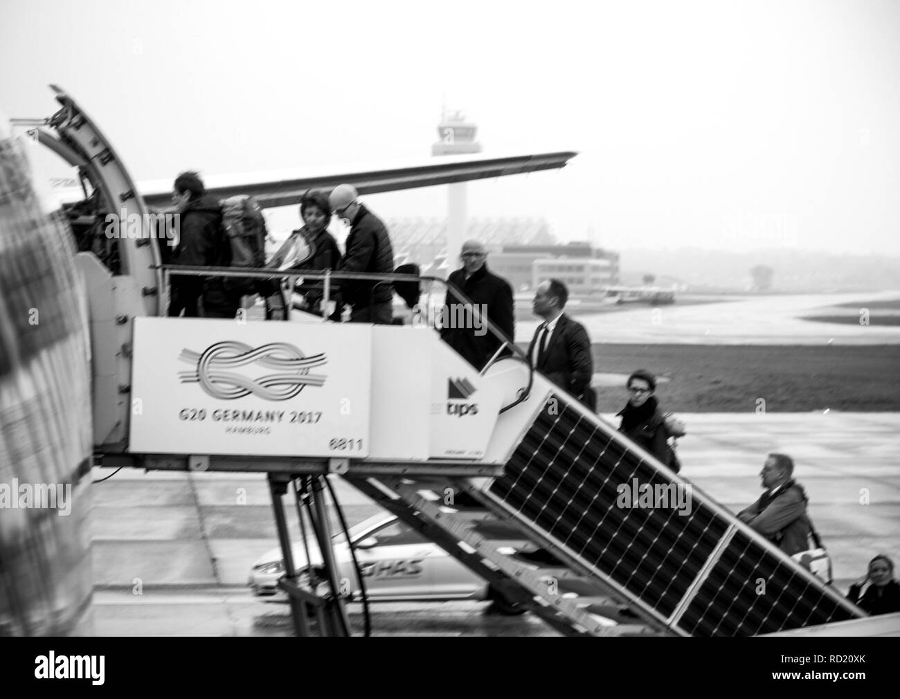 HAMBURG, DEUTSCHLAND - Mar 22, 2018: schwarz Defokussierten und weiß von Menschen, die EasyJet Flugzeug am frühen Morgen im Flughafen Hamburg durch die hintere Beifahrertür jetway Treppen Stockfoto