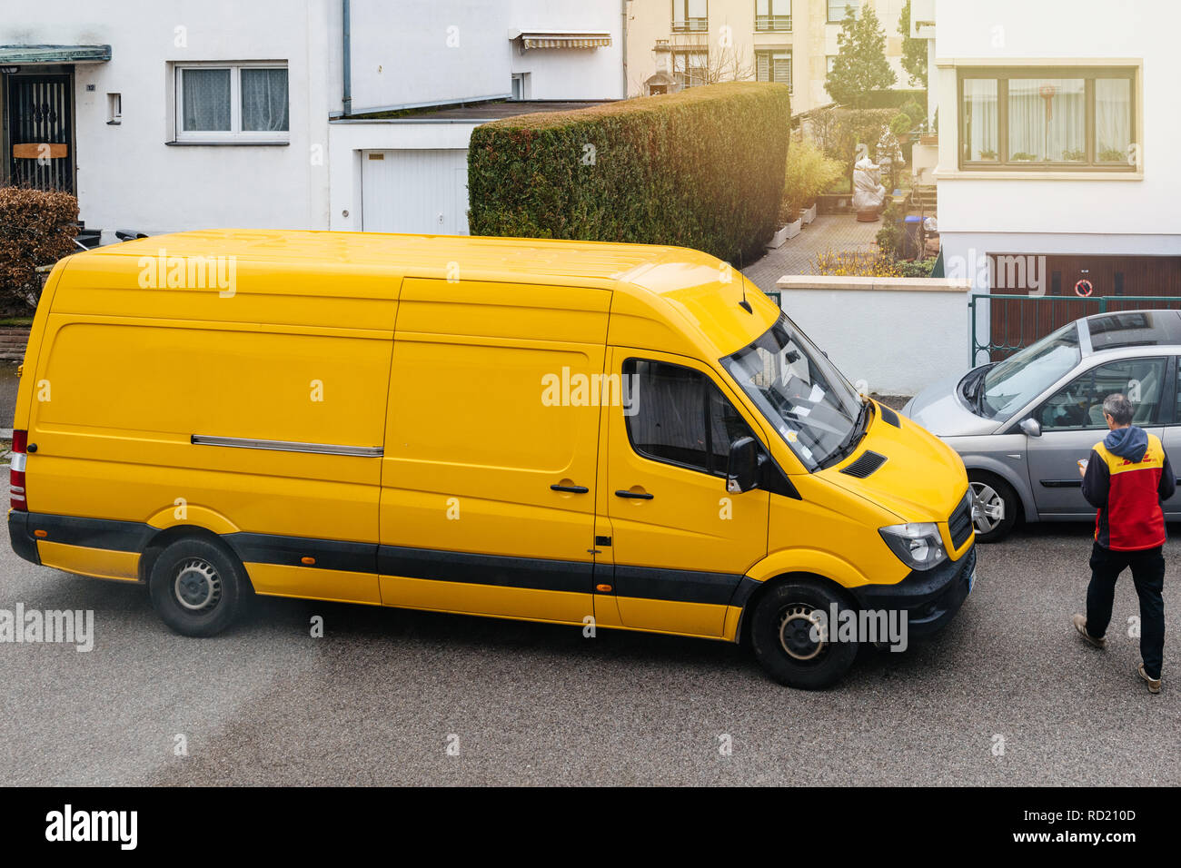 PARIS, Frankreich, 30.MÄRZ 2018: Kurier trägt DHL gelben Lieferwagen nach  der Lieferverzug Paket Paket in der typisch europäischen Nachbarschaft -  Ansicht Stockfotografie - Alamy