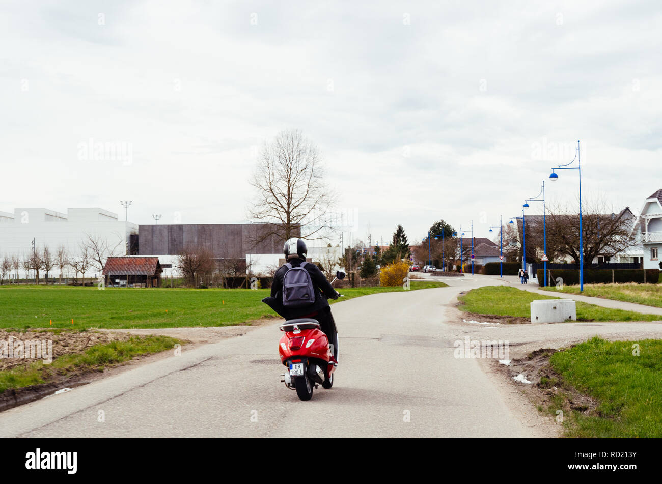 Straßburg, Frankreich - Apr 2, 2018: Ansicht der Rückseite des Jungen unbeschwerten Frau reiten Italienische Vespa Primavera 5 rote Roller auf einer Landstraße in der Nähe von Straßburg Stockfoto