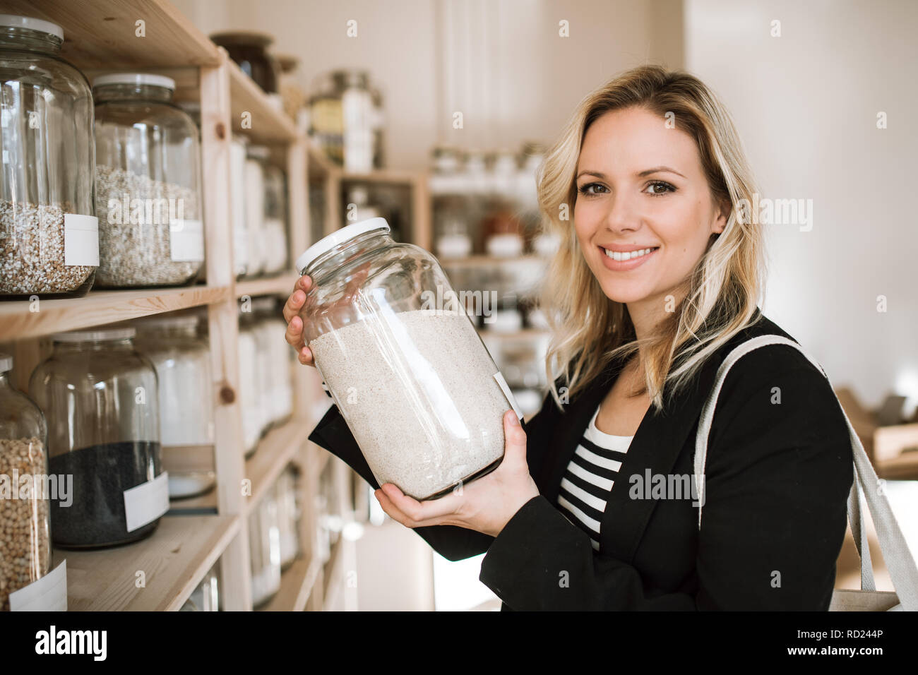 Eine junge Frau kaufen Lebensmittel in null Abfall Shop. Stockfoto