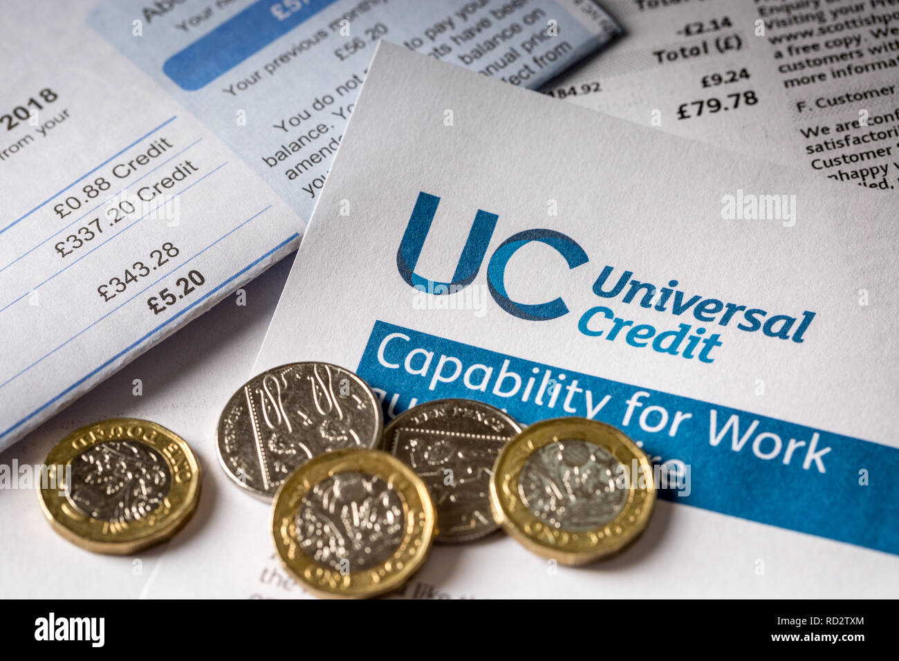 UK Universal Kredit Form mit einem Stapel unbezahlter Rechnungen Stockfoto
