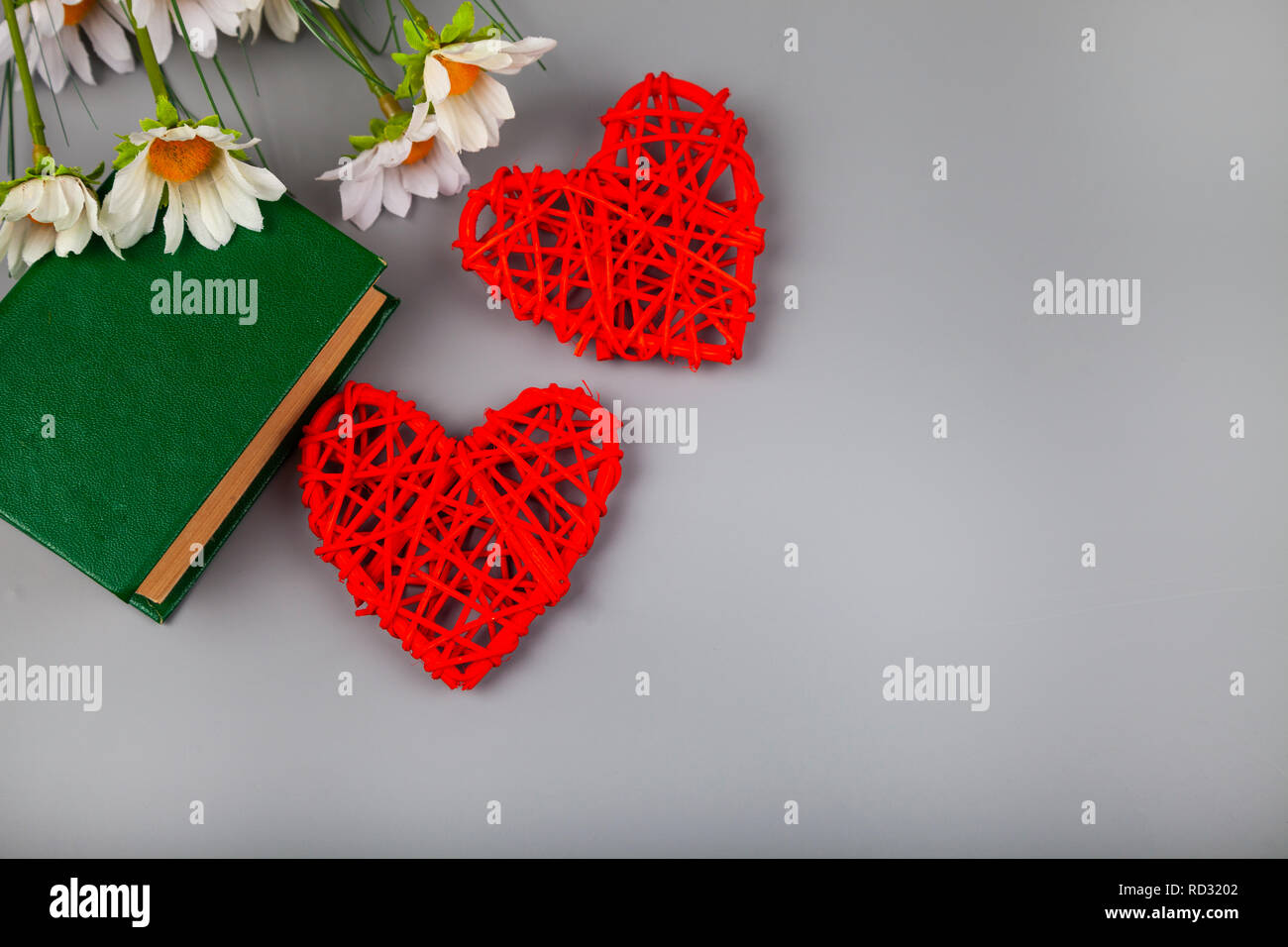 Buchen Sie mit romantischen Gedichten, Blumen und zwei Herzen. Geschenk für den Valentinstag. Stockfoto