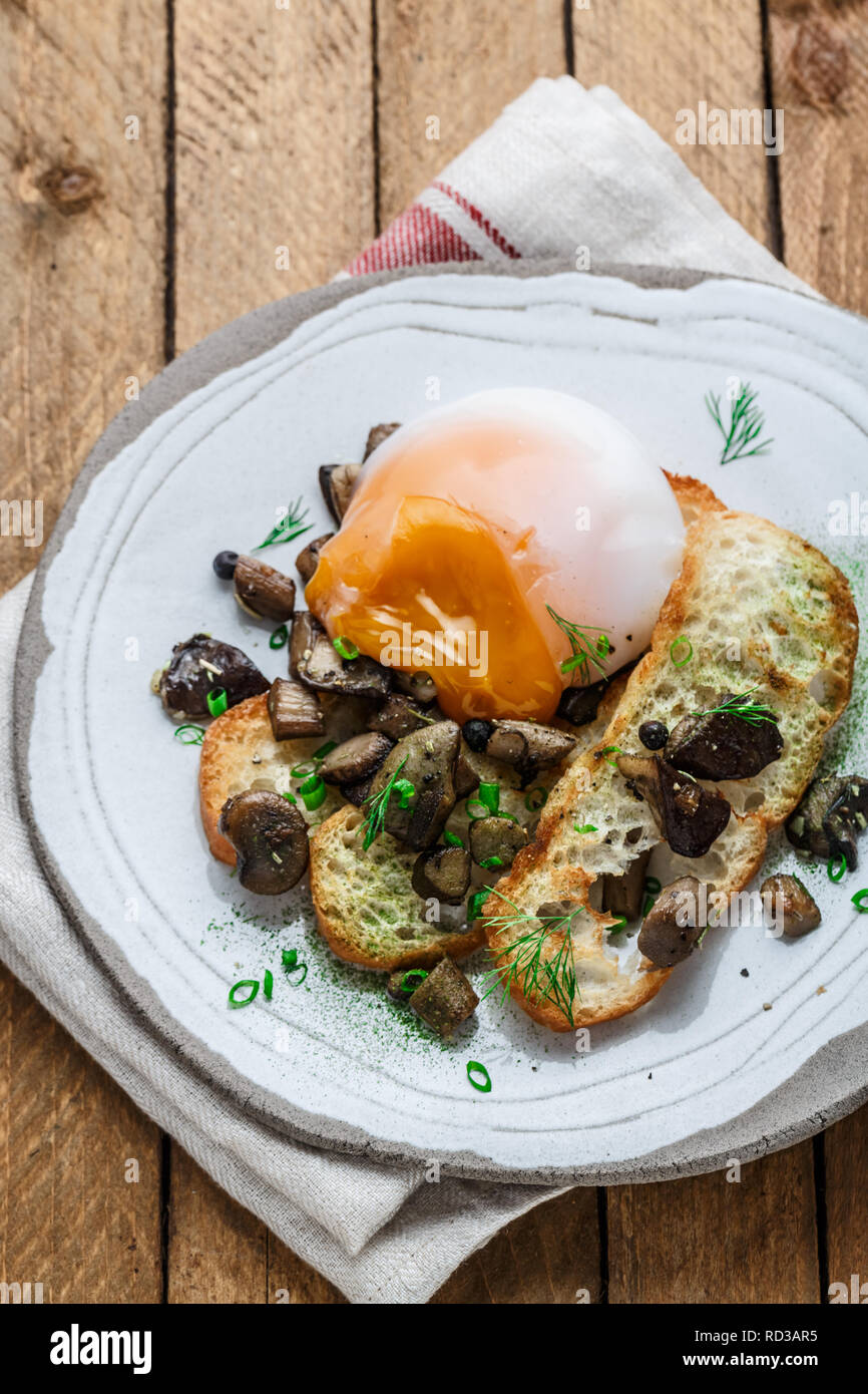 Nahaufnahme des pochierte Eier mit Pilzen und geröstetem Brot Stockfoto