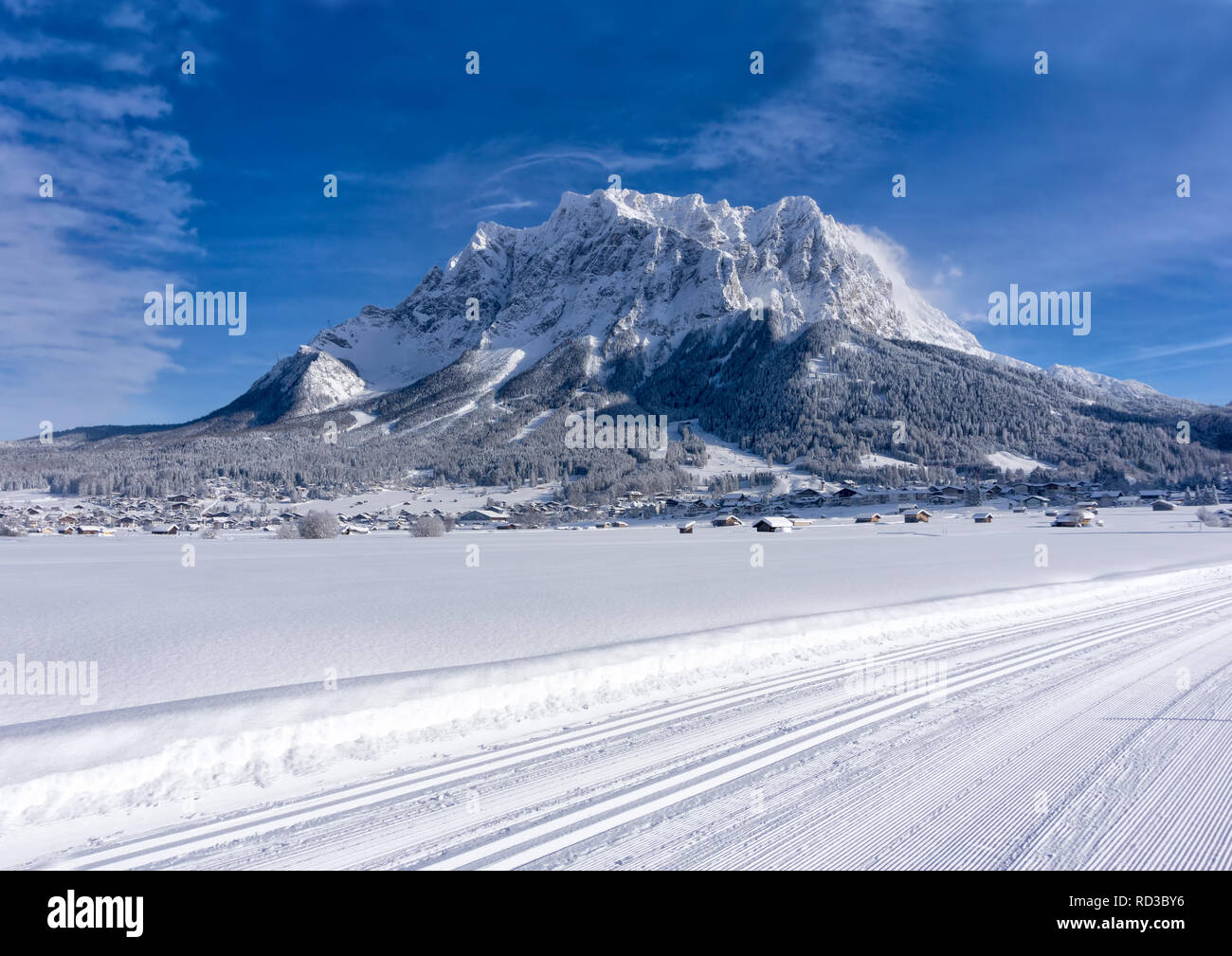 Das Zugspitzmassiv aus dem Tal von Ehrwald im sonnigen Wintertag, präparierte Loipen im Vordergrund. Winter Berglandschaft. Stockfoto