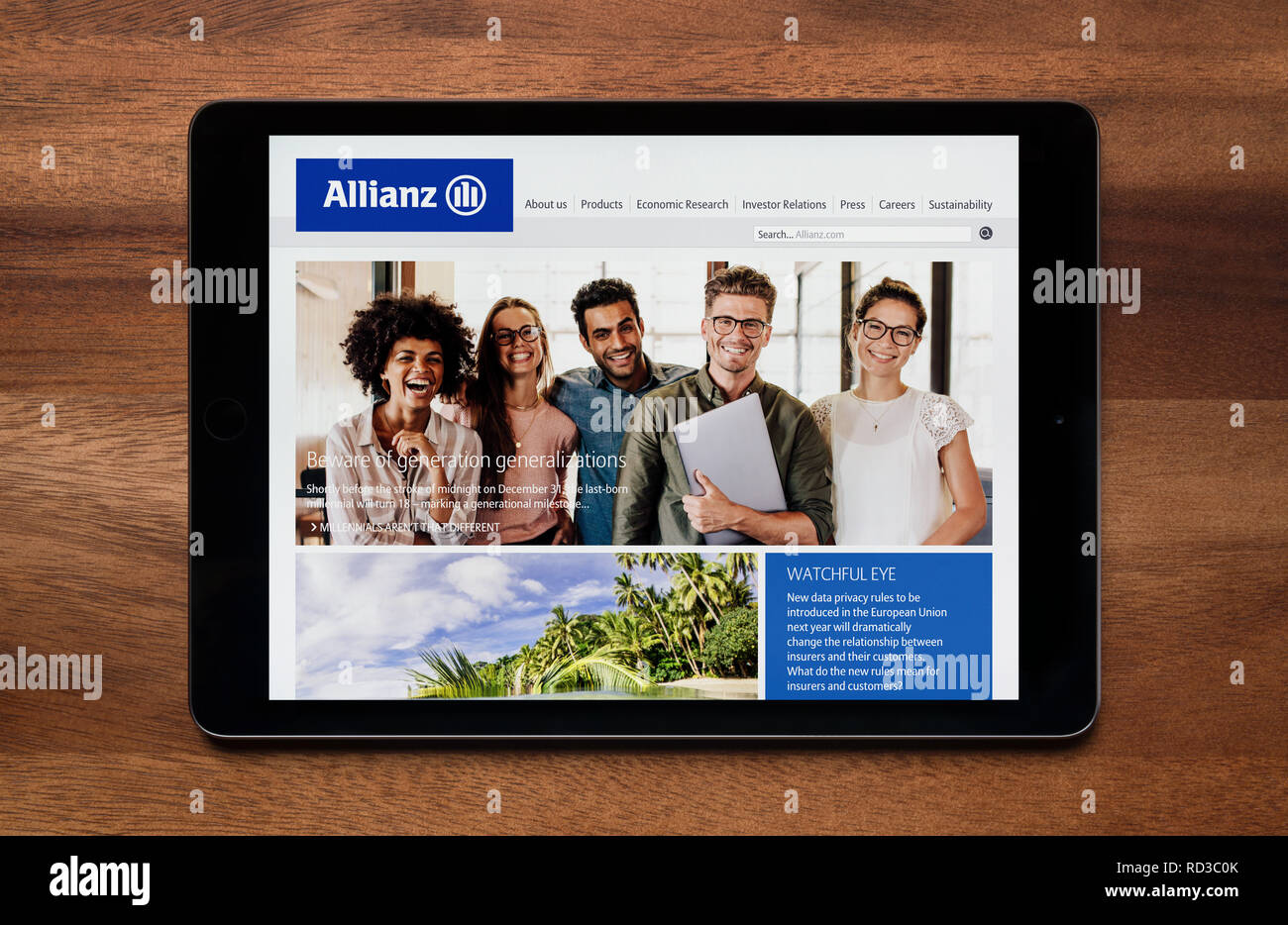 Die Website der Allianz Versicherung ist gesehen auf einem iPad Tablet, der ruht auf einem Holztisch (nur redaktionelle Nutzung). Stockfoto