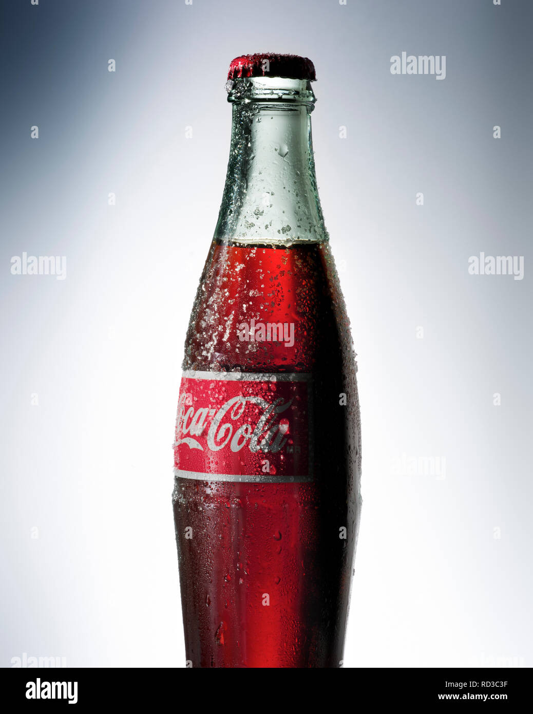 Zugeschnittenes Bild von Coca Cola Glas Flasche mit Etikett Stockfoto