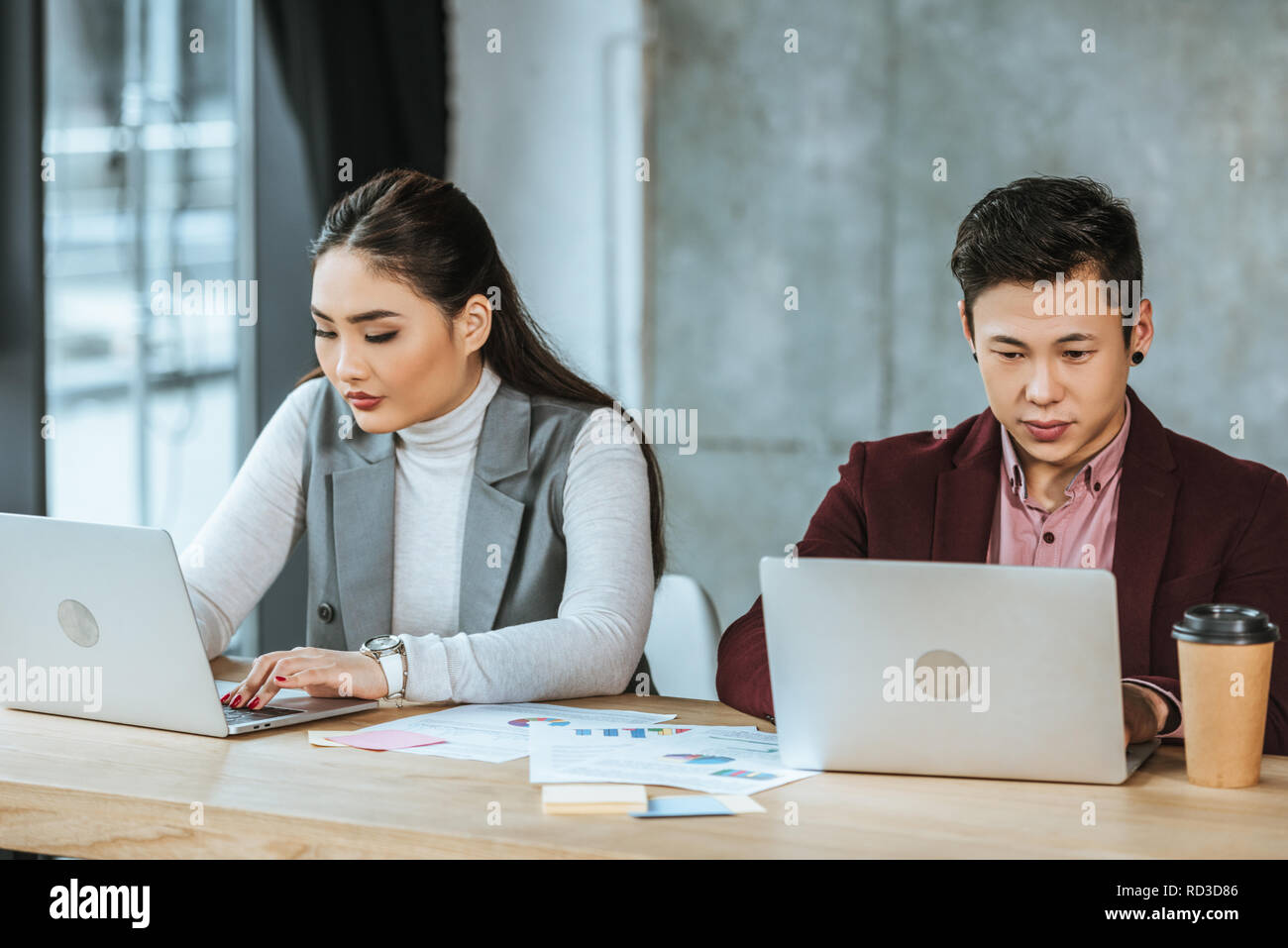 Konzentrierte sich die jungen kasachischen Geschäftsleute mit Laptops am Arbeitsplatz Stockfoto