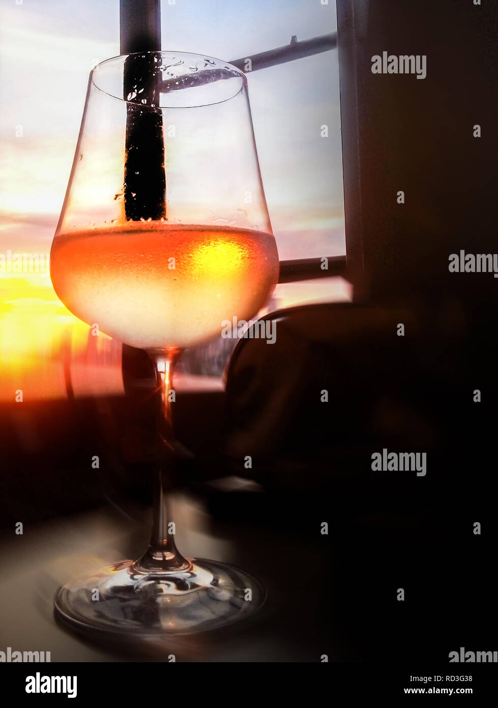 Ein Glas Weisswein auf einem Tisch bei Sonnenuntergang Stockfoto