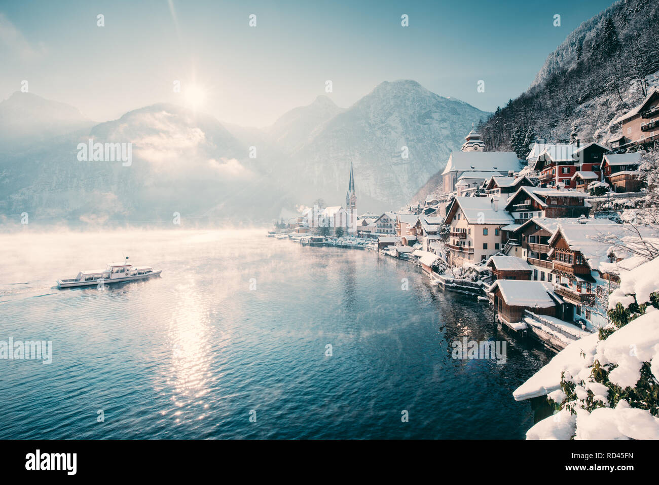Klassische Ansicht der berühmten Hallstätter See Stadt in den Alpen mit Fahrgastschiff auf einem schönen kalten sonnigen Tag mit blauen Himmel und Wolken im Winter Stockfoto