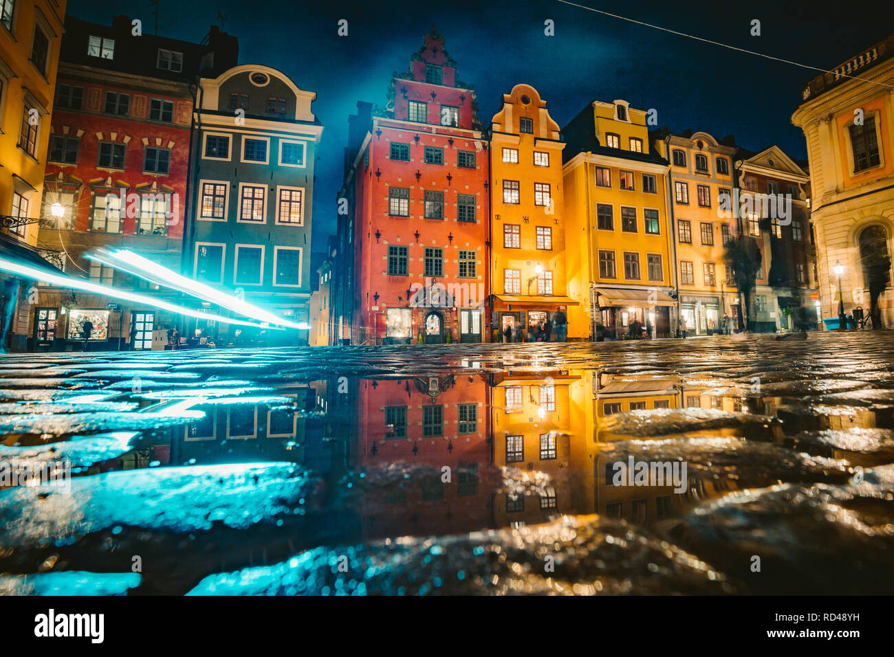 Klassische Ansicht der bunten Häusern an der berühmten stortorget Stadtplatz in der Stockholmer Altstadt Gamla Stan (Altstadt) reflektiert in einer Pfütze in der Nacht Stockfoto