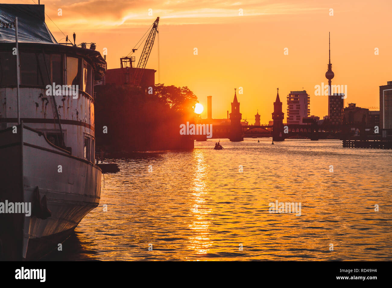 Panoramablick auf Berlin Skyline mit berühmten Fernsehturm und Oberbaumbrücke mit alten Schiffswrack liegen in der Spree bei Dämmerung, Berlin, Deutschland Stockfoto