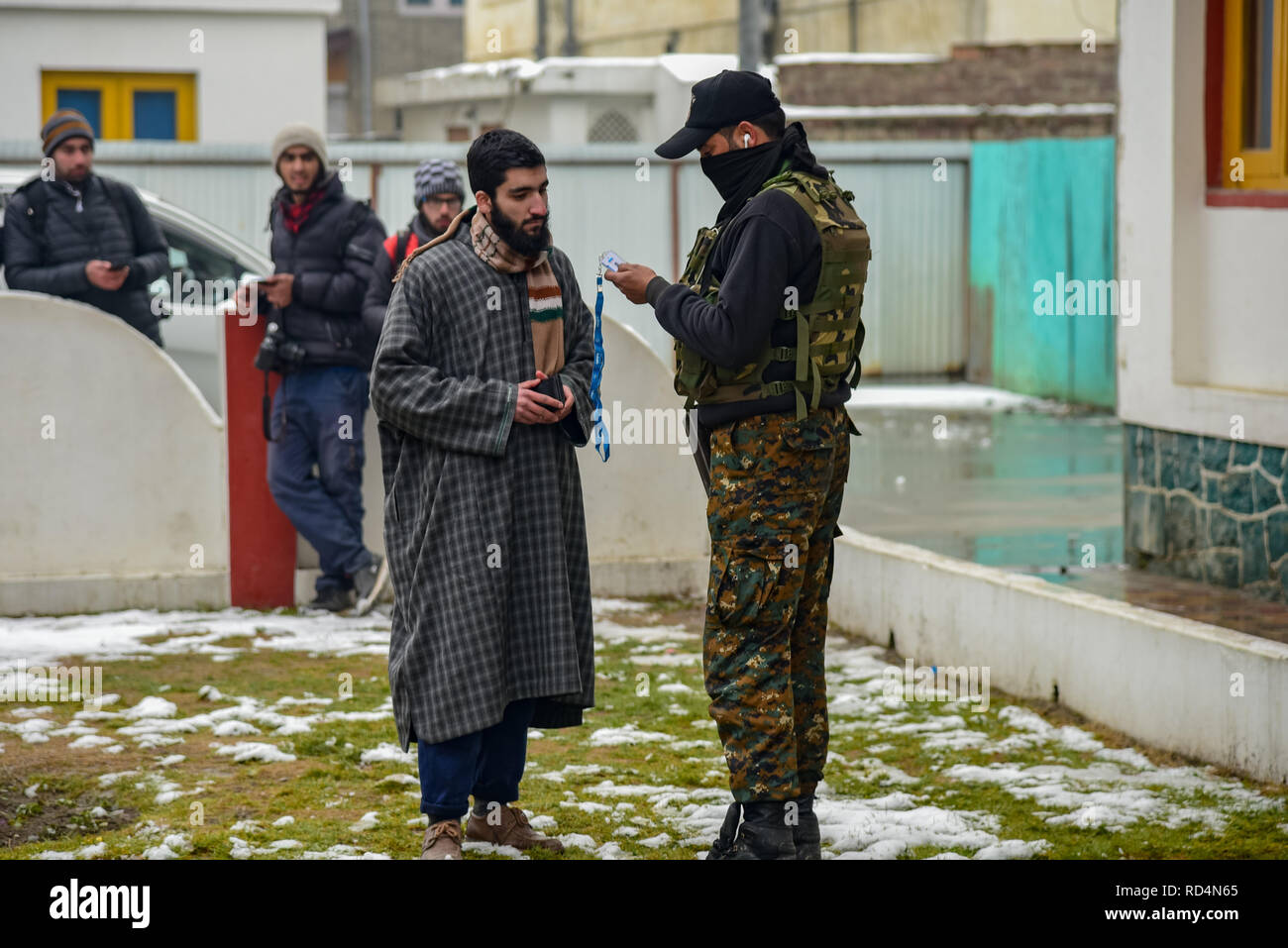Ein Mitglied der speziellen Betrieb Gruppe (SOG) gesehen Abfrage ein Kursteilnehmer während der Suche in Srinagar. Nach Angaben der Polizei wurden mindestens fünf Mitglieder der Regierung Kräfte waren am Donnerstag in einer Granate explosion Schuld auf Rebellen kämpfen gegen indische Herrschaft im indischen Kaschmir verletzt - der größten Stadt gesteuert. Stockfoto