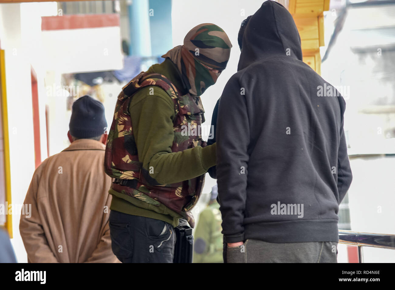 Ein Mitglied der speziellen Betrieb Gruppe (SOG) gesehen Abfrage ein Kursteilnehmer während der Suche in Srinagar. Nach Angaben der Polizei wurden mindestens fünf Mitglieder der Regierung Kräfte waren am Donnerstag in einer Granate explosion Schuld auf Rebellen kämpfen gegen indische Herrschaft im indischen Kaschmir verletzt - der größten Stadt gesteuert. Stockfoto