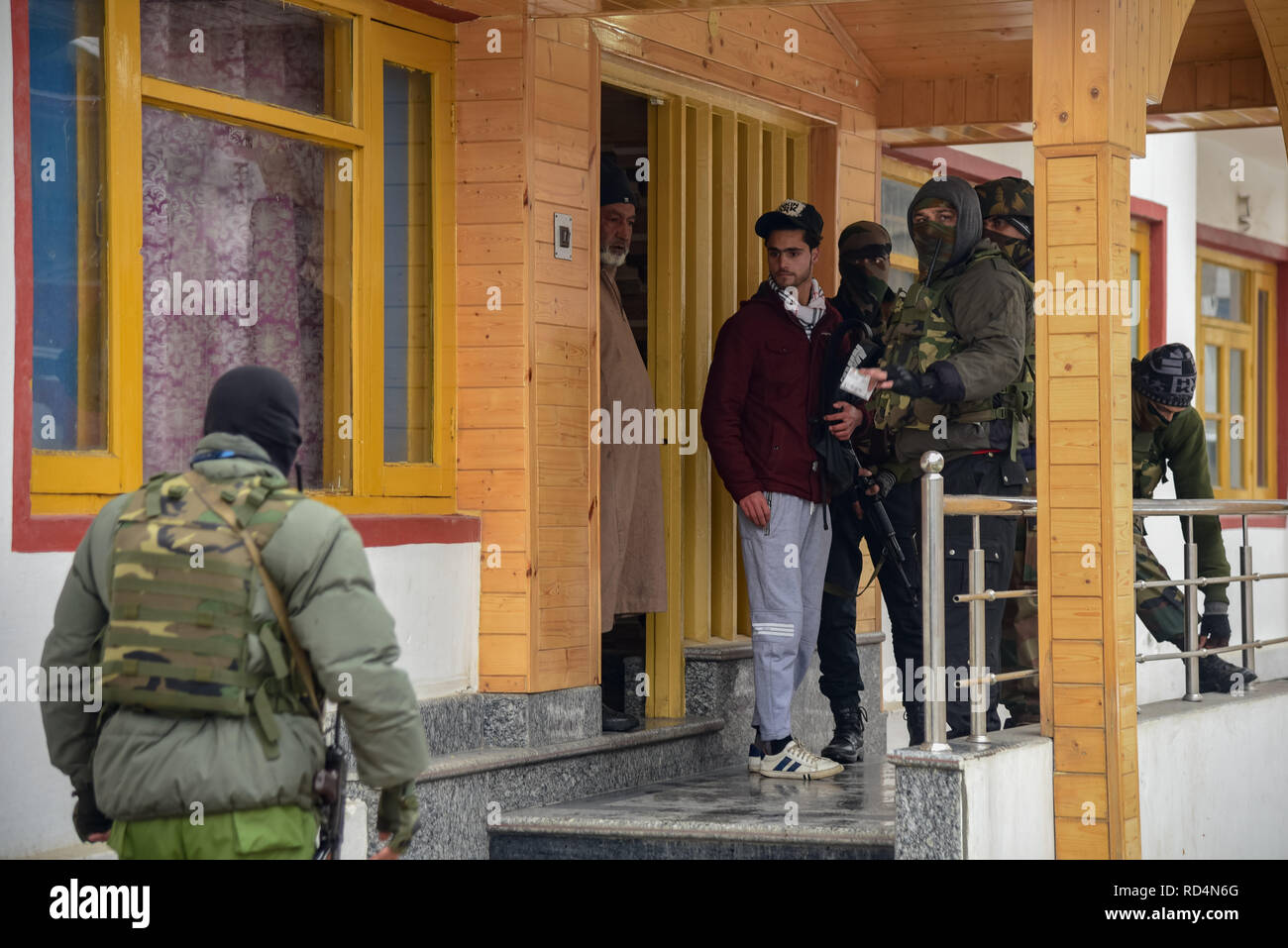 Ein Mitglied der speziellen Betrieb Gruppe (SOG) gesehen Abfrage ein Kursteilnehmer während der Suche in Srinagar. Nach Angaben der Polizei wurden mindestens fünf Mitglieder der Regierung Kräfte waren am Donnerstag in einer Granate explosion Schuld auf Rebellen kämpfen gegen indische Herrschaft im indischen Kaschmir verletzt - der größten Stadt gesteuert. Stockfoto