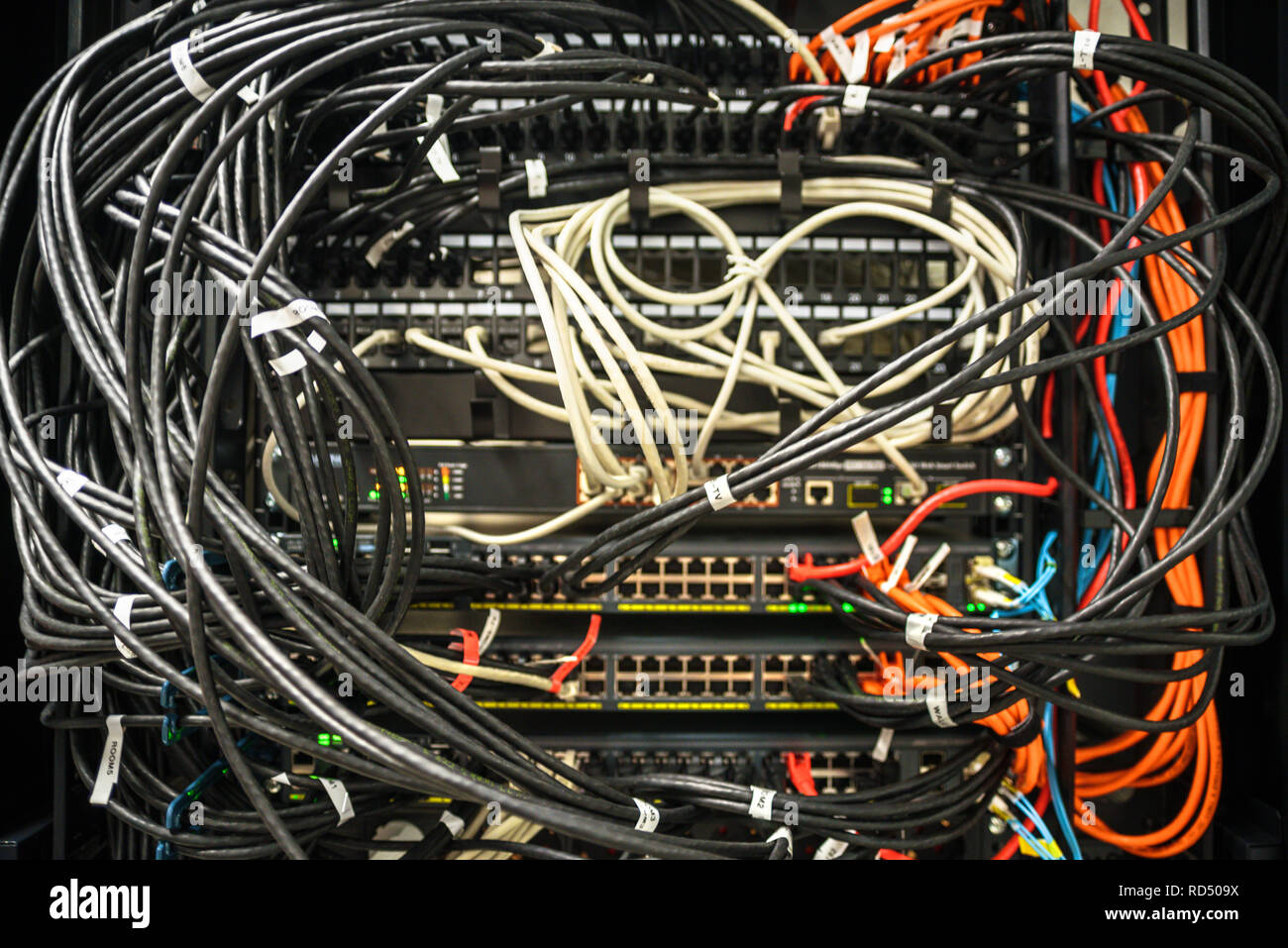 Netzwerk Hardware in ein Chaos. Etiketten mit Portnummern auf Drähte Stockfoto