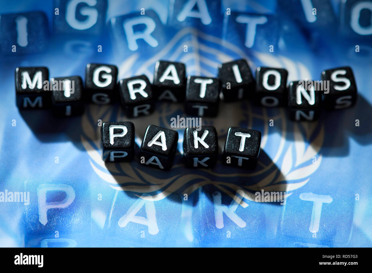 Buchstaben das Wort Migration Pakt zu UN-Flagge, Buchstaben formen das Johanniskraut Migrationspakt in UN-Fahne Stockfoto