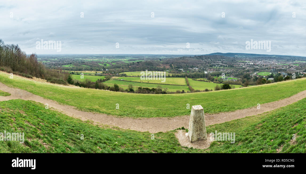 Panorama von Box Hill in der Surrey Hills, England, Großbritannien, mit einem trig Point im Vordergrund und Bauernhöfe, Felder und die Stadt Dorking. Stockfoto