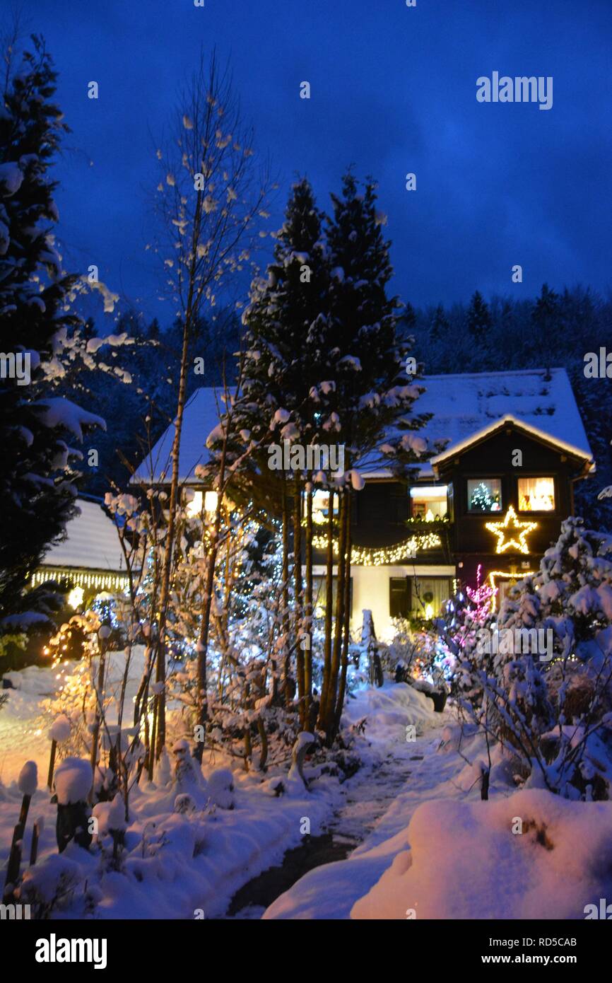 Kleines Haus mit Schnee bedeckt und chtistmas Lichter im malerischen Bad Goisern, Hallstatt. Österreich. Nightfall anzeigen. Stockfoto