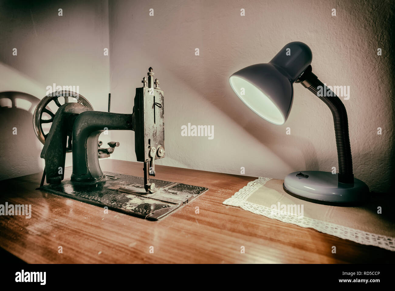 Lampe und alte Nähmaschine auf Arbeitstisch Stockfoto