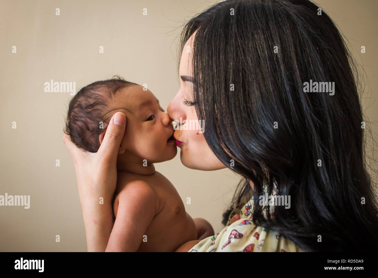 Hispanic Mutter küssen neugeborenes Baby Stockfoto