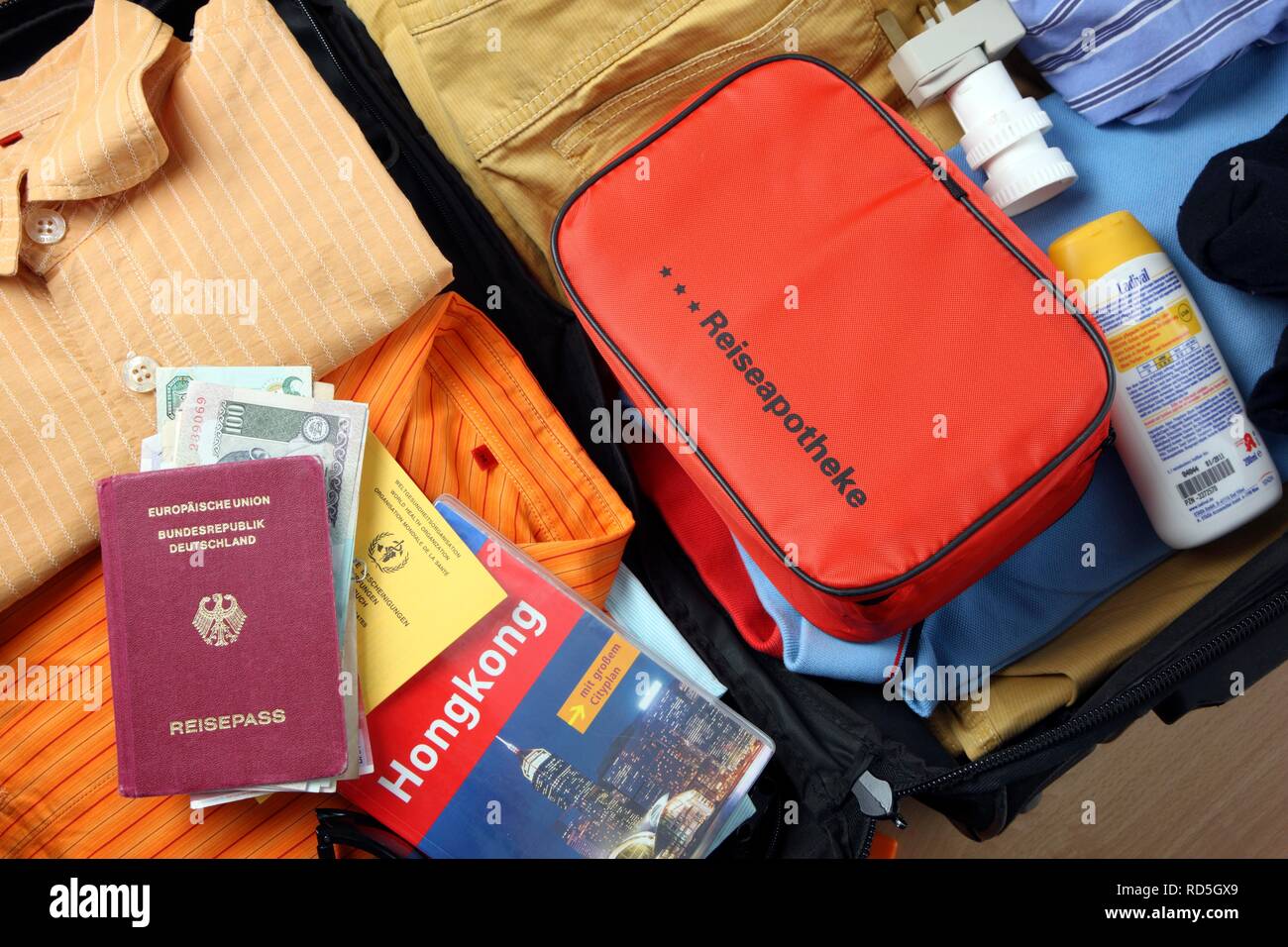 Urlaub koffer, Erste-Hilfe-Kasten, Reisepass, Impfpass, Reiseführer Stockfoto