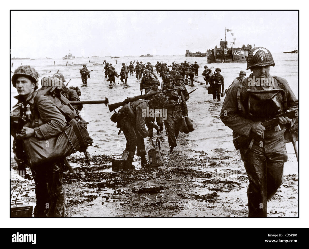 D-DAY OMAHA BEACH NORMANDIE FRANKREICH GI Soldaten der US-Armee Verstärkungen Land auf Omaha Beach in der Normandie D-Day Landungen in der Nähe von Vierville-sur-Mer, Frankreich, am 6. Juni 1944 Stockfoto