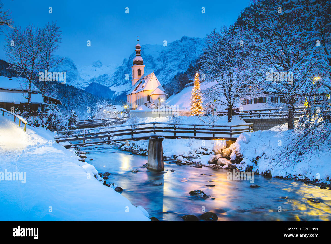 Schöne Dämmerung Blick auf Sankt Sebastian Wallfahrtskirche mit geschmückten Weihnachtsbaum während der Blauen Stunde in der Dämmerung im Winter beleuchtet, Ramsau Stockfoto