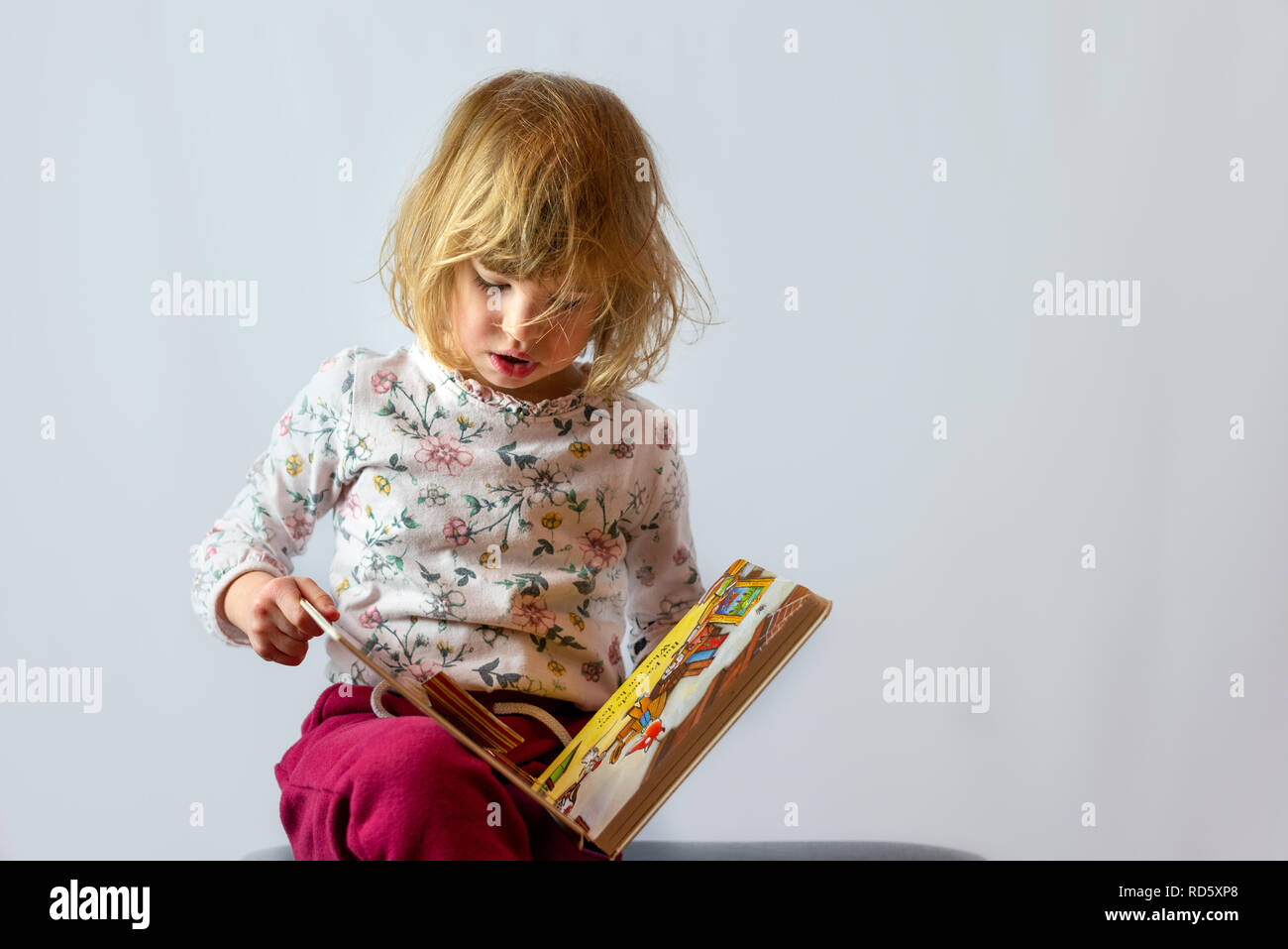 Vorschule Mädchen lesen Book Studio Portrait auf sauberen Hintergrund Stockfoto