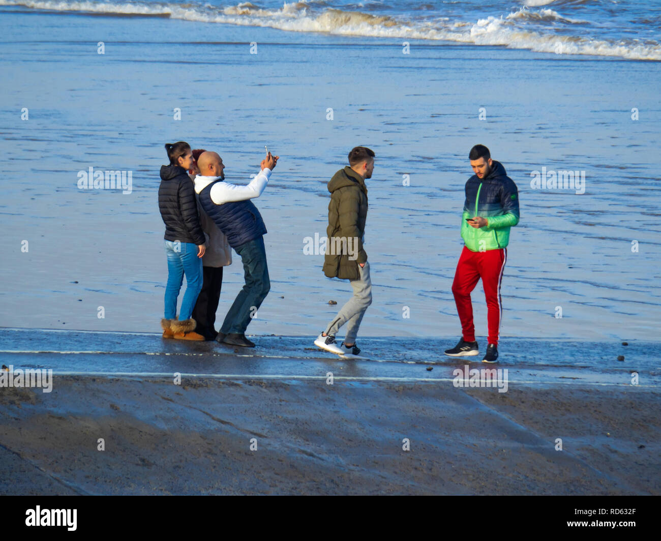 Junge Erwachsene auf einer Helling in Redcar Strand North Yorkshire ein Mann schießt selfie während nach hinten gebogen Stockfoto