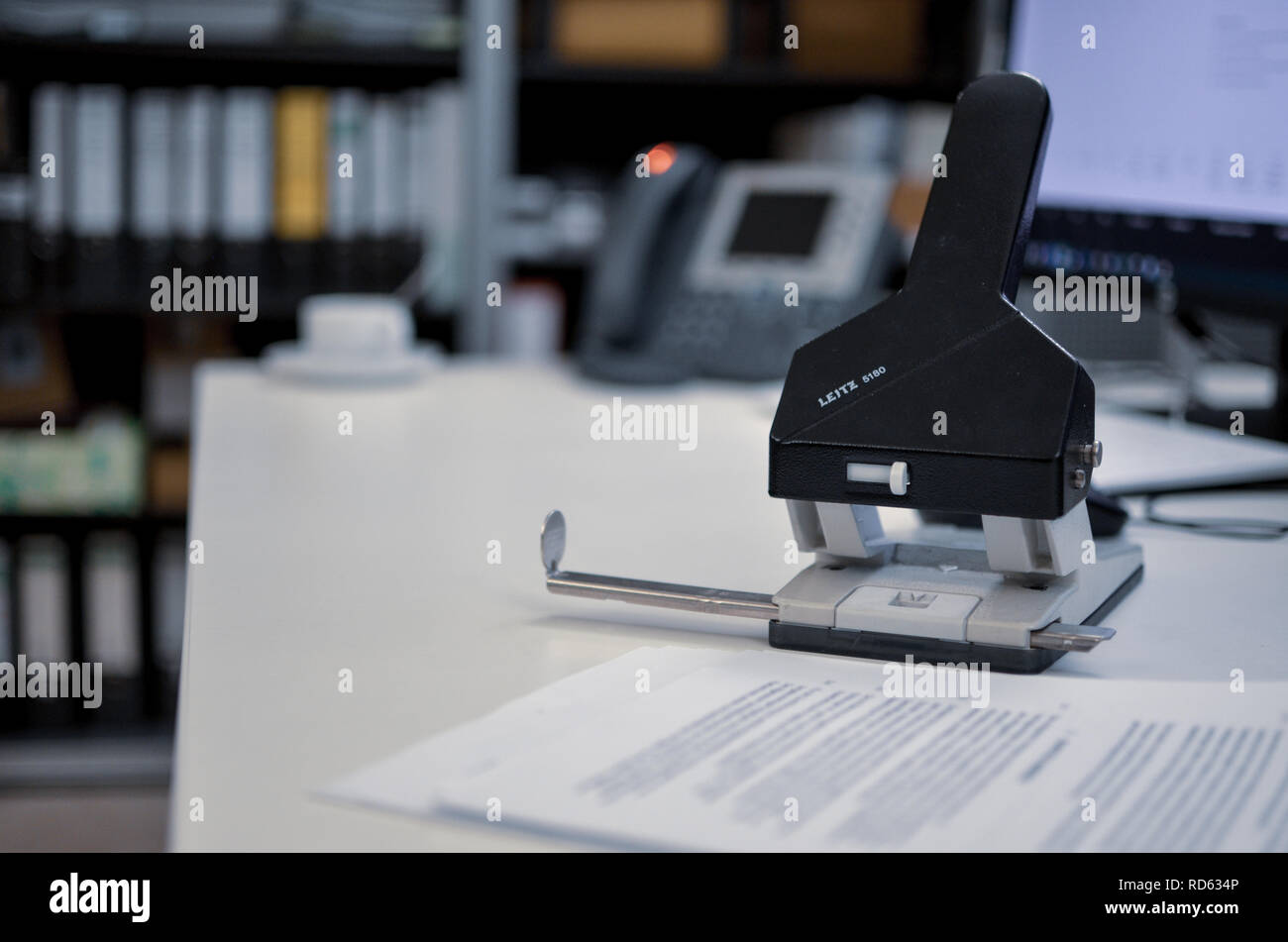 Ein schwarzes Loch stanzen mit Papier auf einem weißen Schreibtisch in einem Büro Stockfoto