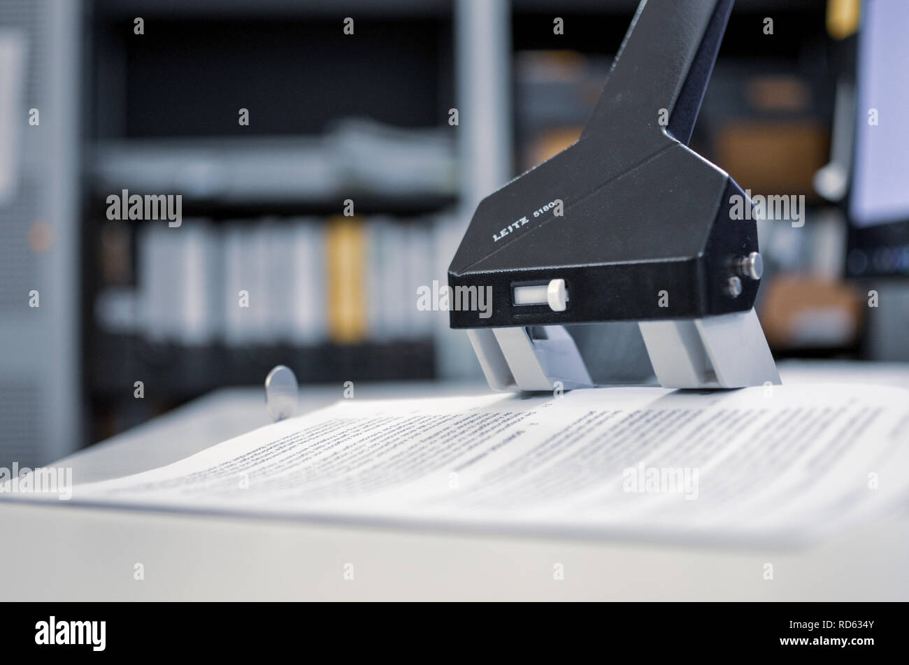 Ein schwarzes Loch stanzen mit Papier auf einem weißen Schreibtisch in einem Büro Stockfoto