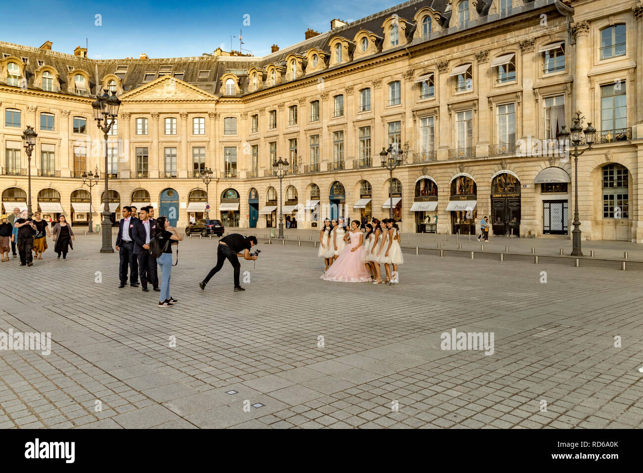 Ein Fotograf nimmt ein Bild eines chinesischen Braut in ihrem Brautkleid mit ihre brautjungfern an ihrer Seite an der Place Vendome, Paris, Frankreich Stockfoto