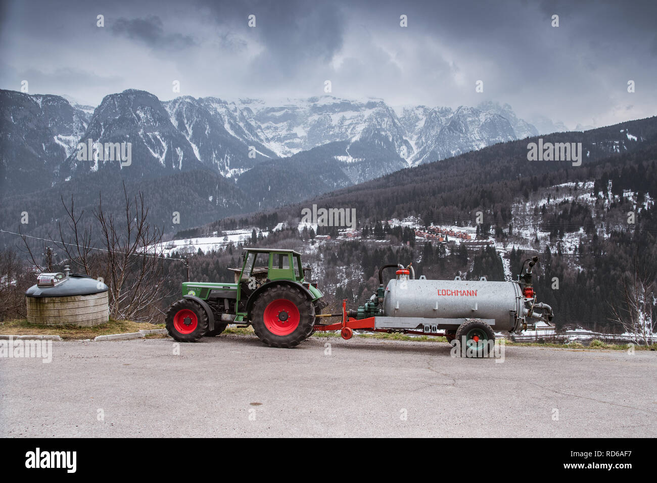 Traktor Fendit 280 S mit Anhänger - Gülle tanker Lochmann, die auf dem Hintergrund der Berge Stockfoto