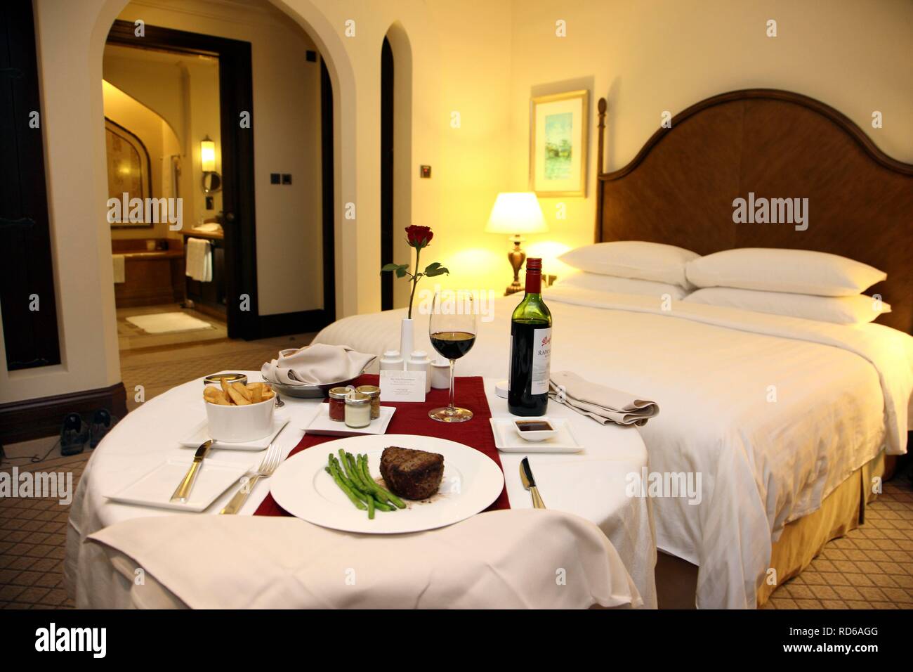 Zimmerservice im Hotel, Abendessen im Hotel Zimmer, Steak, Beilagen und Wein, auf einem gedeckten Tisch, Shangri-La Hotel Stockfoto