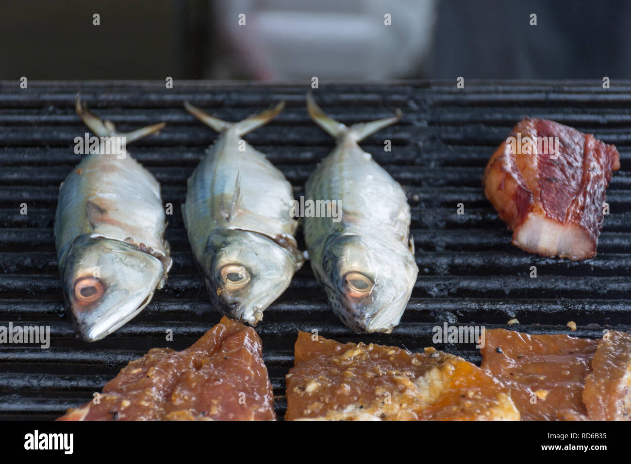 Fisch kochen auf einem BBQ-Grill mit anderen Fleischsorten. Stockfoto