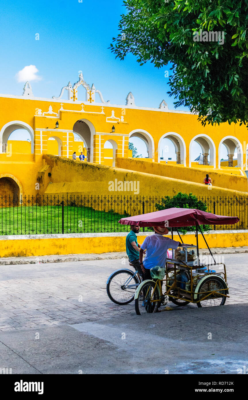 IZAMAL, Yucatan/Mexiko - 10. NOVEMBER 2018: Straße Verkäufer auf seinem Dreirad vor dem Kloster von Izamal, die gelbe Stadt namens Stockfoto