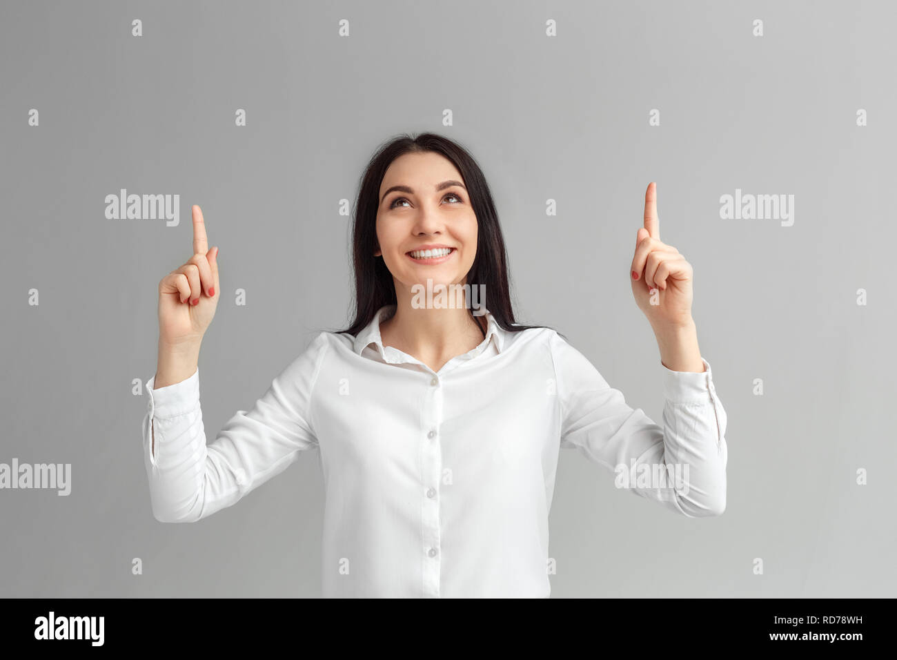 Freestyle. Frau, die isoliert auf Grau nach oben heiter Stockfoto