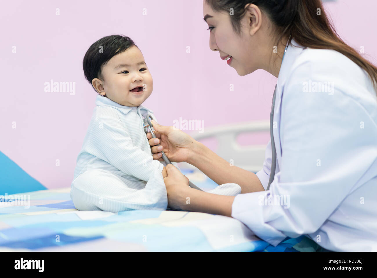 Asiatische Arzt Frau Prüfung eines kleinen Jungen durch Stethoskop im Krankenhaus. Medizin und Gesundheit Konzept. Stockfoto