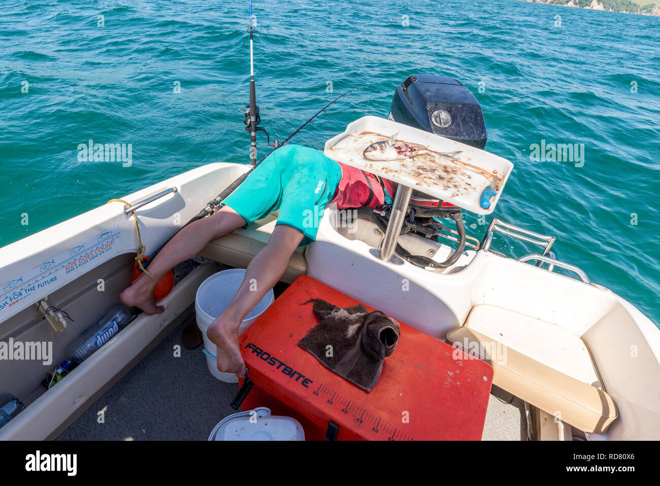 Fischer gebogen über Boot Stockfoto