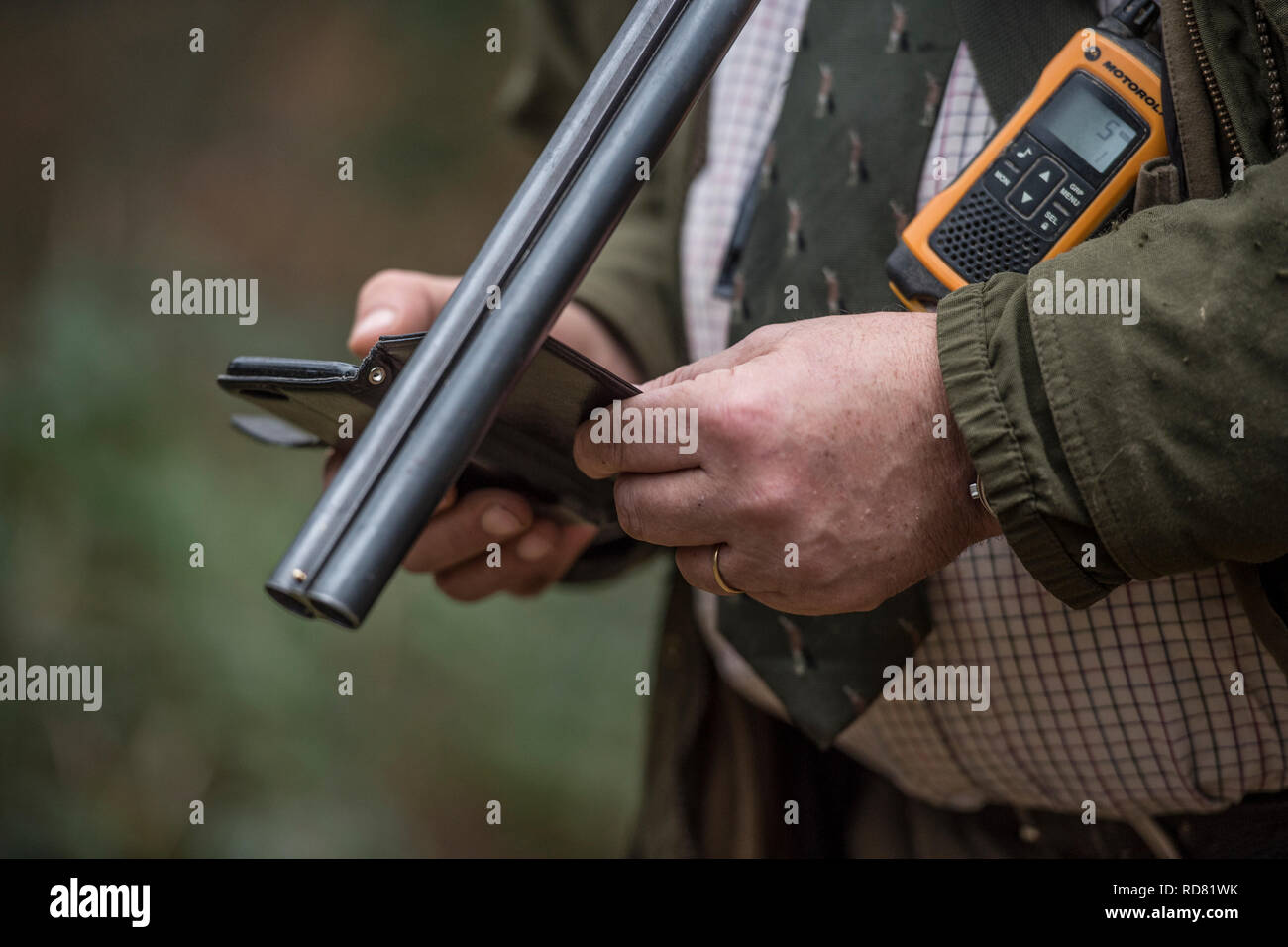 Mann mit Schrotflinte und Mobiltelefon Stockfoto