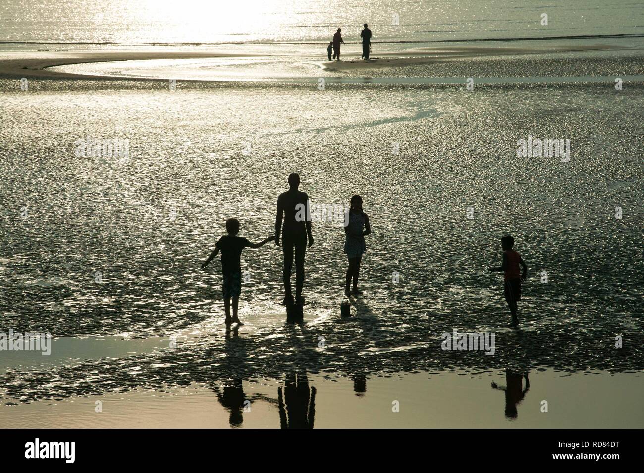 Sir Antony Gormley geschnitzten Figuren, mit refleccted Touristen im Gezeiten Pool. Ein weiterer Ort, Stockfoto