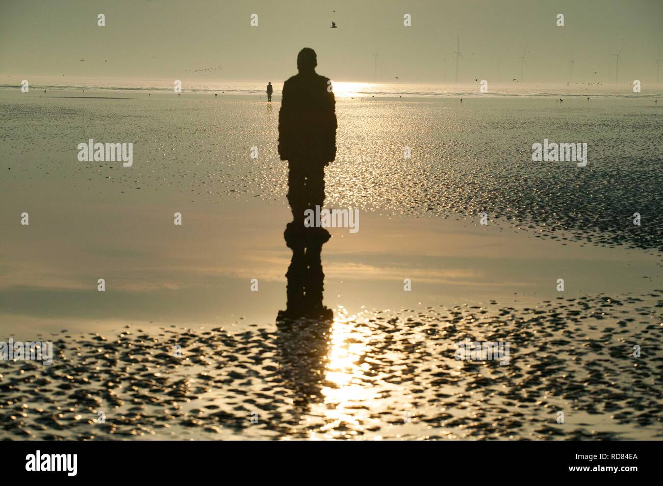 Silouhette von Sir Antony Gormley, einem anderen Ort Skulpturen am Crosby Beach Stockfoto