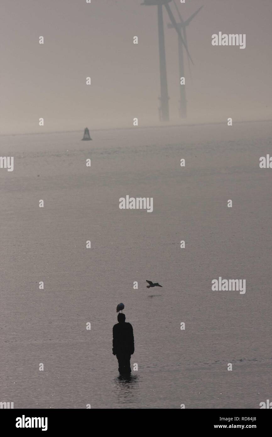 Silouhette von Sir Antony Gormley, einem anderen Ort Skulpturen am Crosby Beach Stockfoto