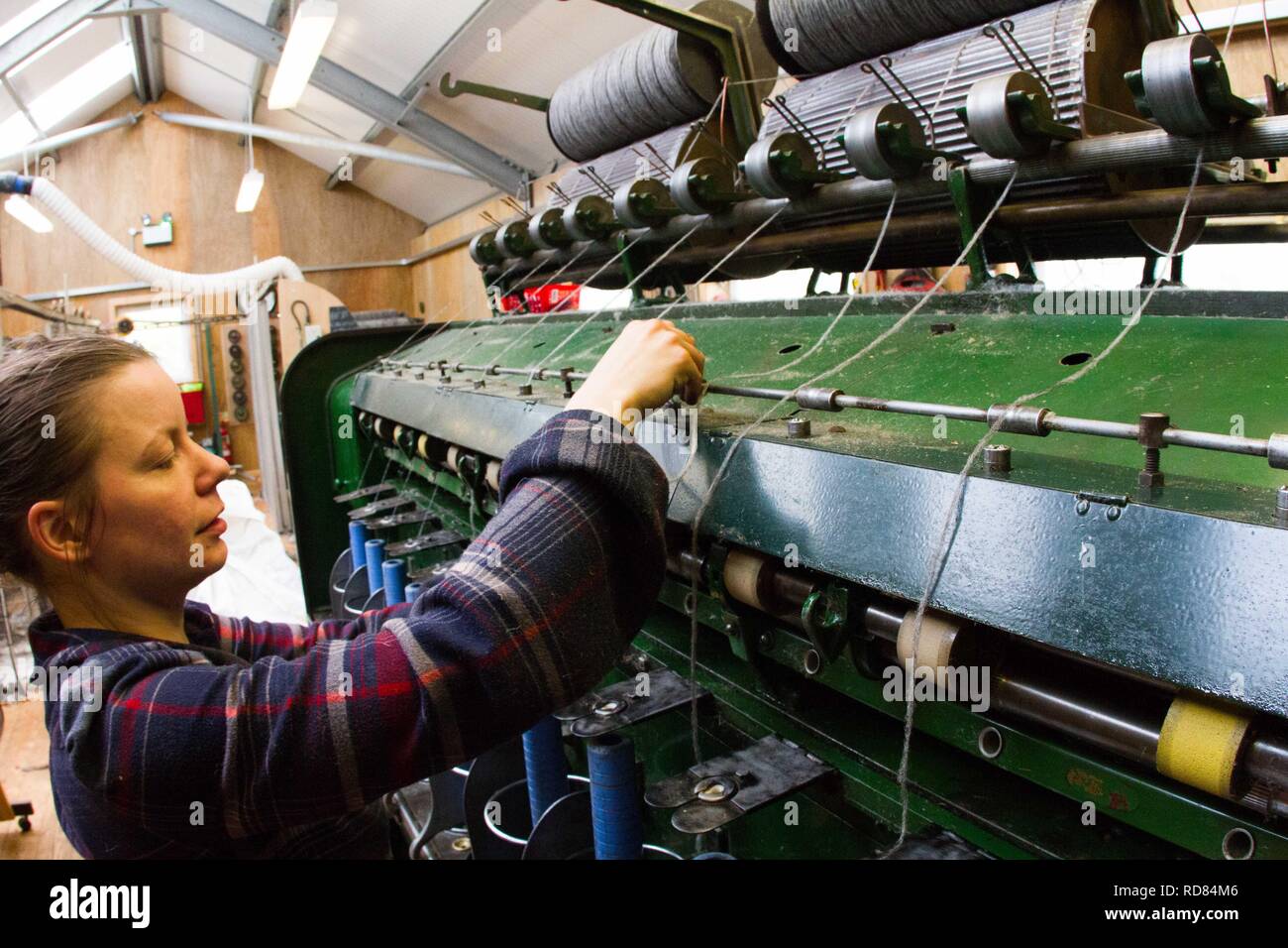 Hoch qualifizierte schwedische Frau mit restaurierten Wolle und Textilmaschinen aus dem 19. Jahrhundert eine Produktionslinie von nachhaltig produzierten Wolle und Textilwaren. Stockfoto