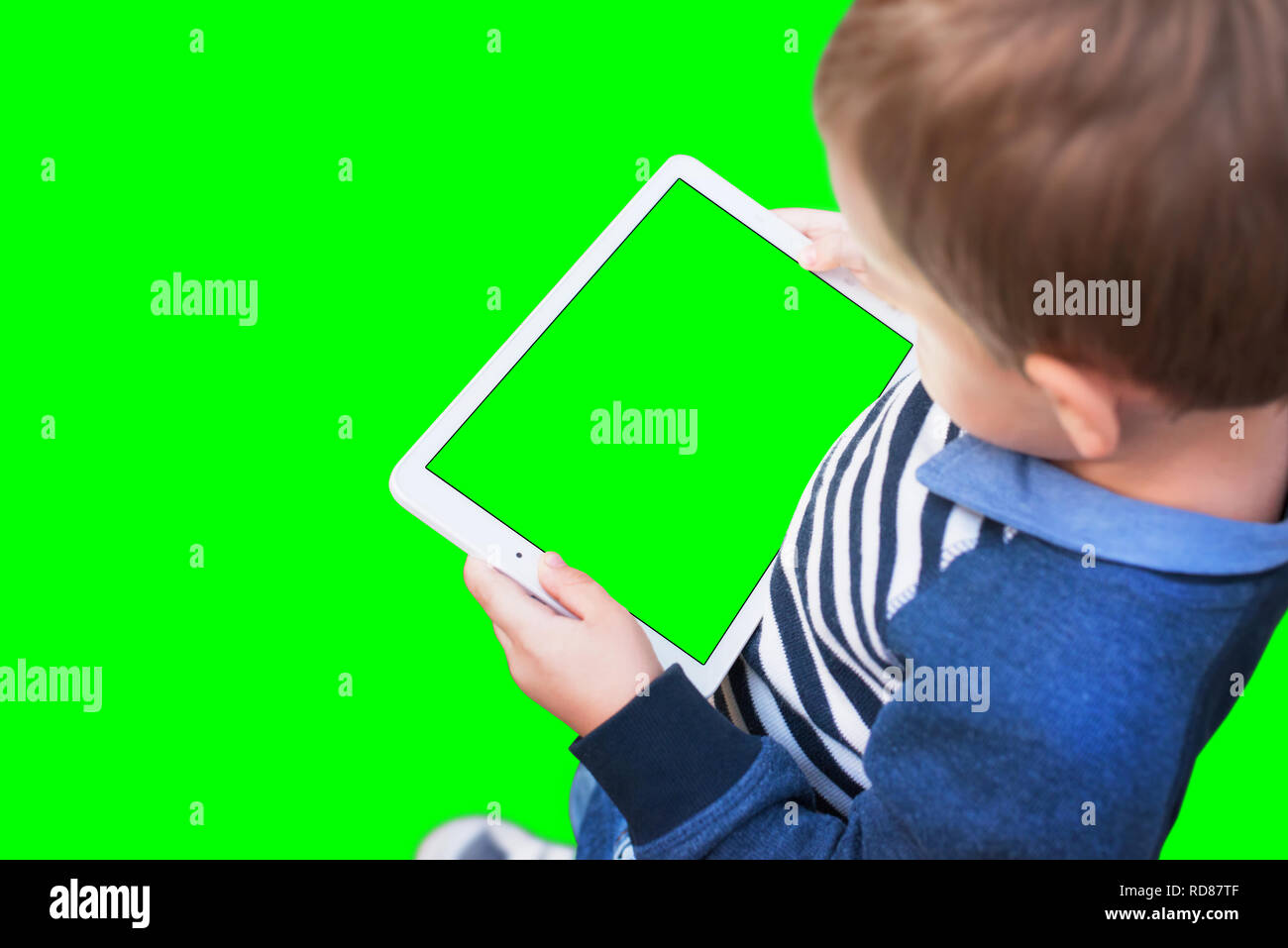 Jungen spielen Spiel auf weiße Tablette. Isolierte Bildschirm und Hintergrund in grün, Chroma Key. Stockfoto
