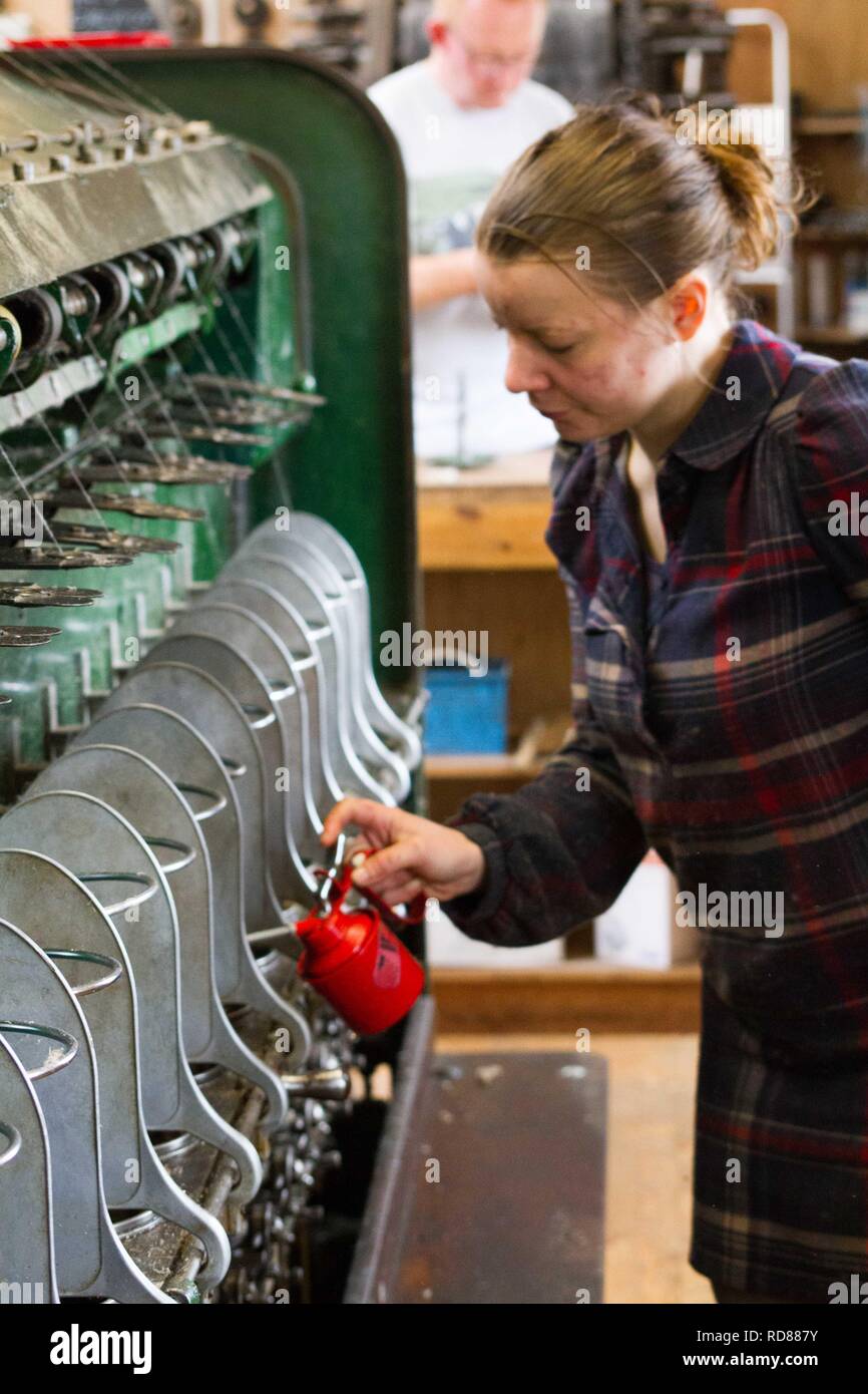 Hoch qualifizierte schwedische Frau mit restaurierten Wolle und Textilmaschinen aus dem 19. Jahrhundert eine Produktionslinie von nachhaltig produzierten Wolle und Textilwaren. Stockfoto