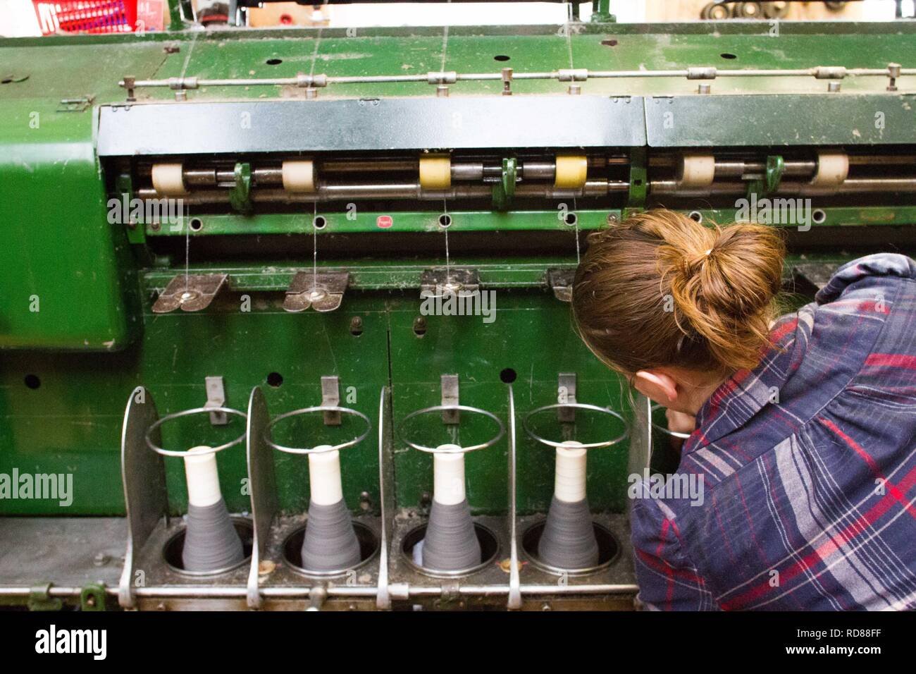 Hoch qualifizierte schwedische Frau mit restaurierten Wolle und Textilmaschinen aus dem 19. Jahrhundert eine Produktionslinie von nachhaltig produzierten Wolle und Textilwaren. Stockfoto