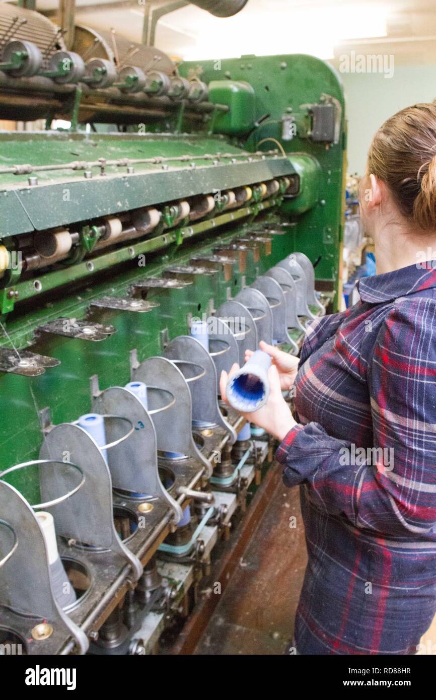 Hoch qualifizierte schwedische Frau mit restaurierten Wolle und Textilmaschinen aus dem 19. Jahrhundert eine Produktionslinie von nachhaltig produzierten Wolle und Textilwaren. Stockfoto