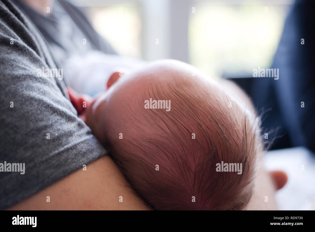Ein neugeborenes Baby mit schwarzem Haar schläft friedlich und süß in die Arme des Vaters mit Kind Vertrauen zu ihm zu klammern, als wenn das Gefühl in it p Stockfoto